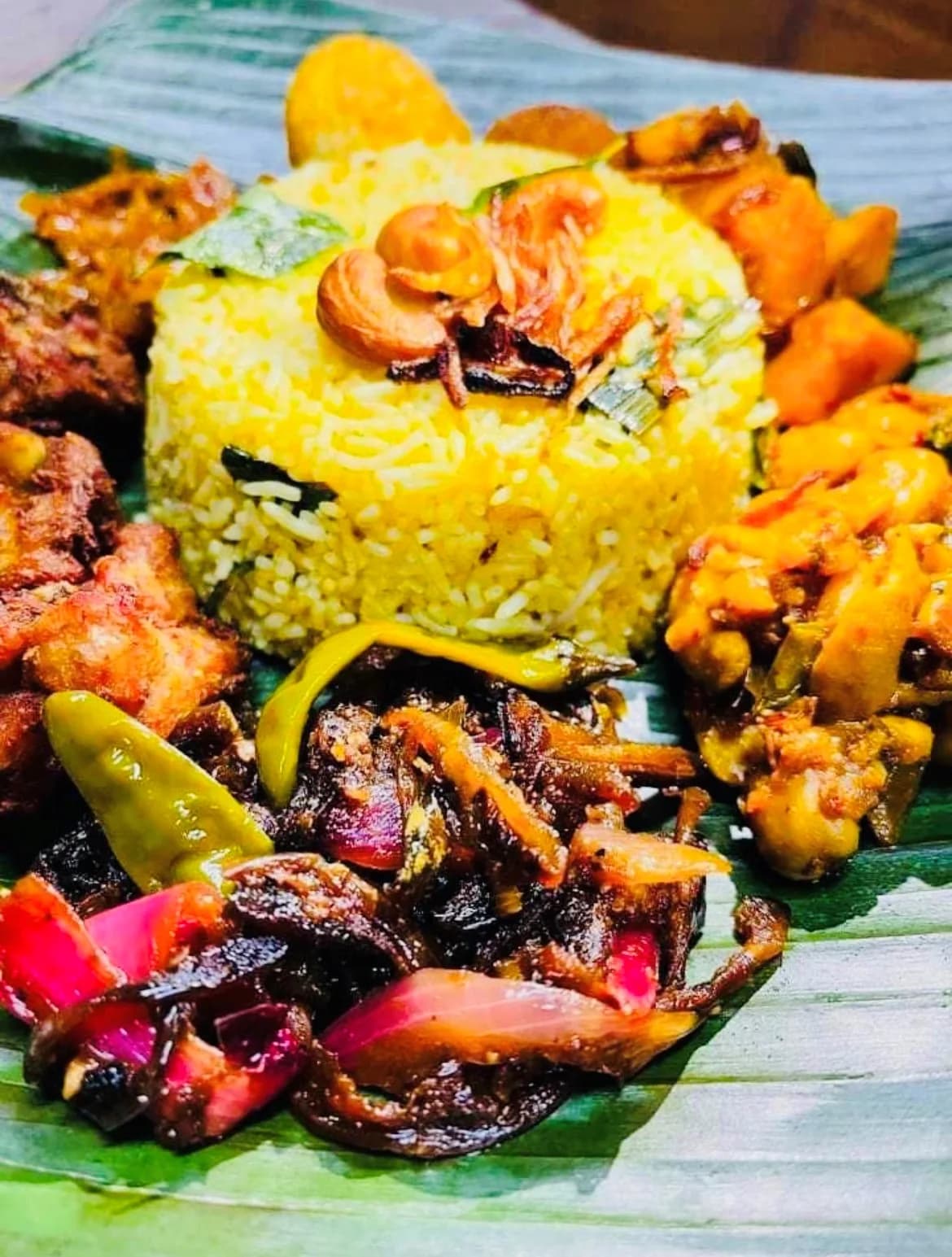 Beautiful banana leaf presentation with yellow rice and multiple Sri Lankan curries