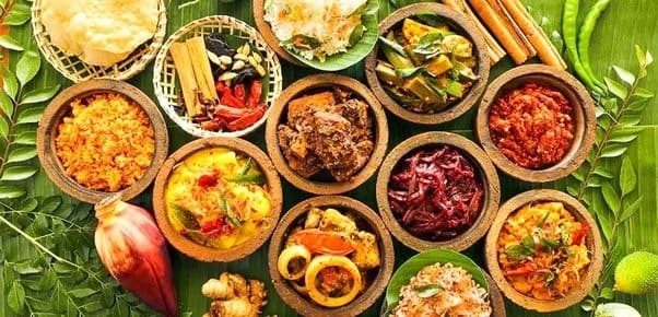 Traditional Sri Lankan feast spread with multiple curries in coconut bowls on banana leaf for private event